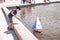 sailing regatta with small toy boats and sailboats run by children and their parents in a pond near