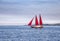 Sailing sailboat with red sails