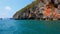 Sailing of speed boat next to a rock islands in