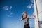 Sailing, tourism, travel and people concept - happy young man in captain hat on a sail boat and showing thumbs up