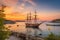 sailing vessel taking in the view of a picturesque seaport at sunset