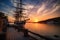 sailing vessel taking in the view of a picturesque seaport at sunset