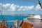 Sailing yacht anchored in tropical bay, with sunny island in a bright blue sky in the background