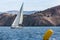 Sailing yacht in the finish during the race regattas near the coastal cliffs