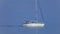 The sailing yacht goes by the calm sea by engine