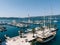 Sailing yacht moored at a tiled pier with potted palm trees