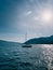 Sailing yacht sails on the sea under bright sunbeams against the backdrop of mountains