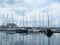 Sailing yachts stand with sails lowered in a small port on a cloudy day