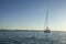 Sailingboat anchored on calm sea near islands