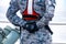 Sailor in grey and dark blue digital pattern camouflage uniform  is holding Walkie Talkie with cross hand on the back