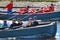 Sailors compete on rowing boats.