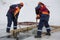 Sailors work at the lane with a fenced wooden formwork