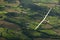 Sailplane soaring across the countryside.