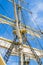 Sails and tackles of a sailing vessel on a background of the sky