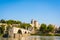 The Saint-Benezet bridge on the Rhone river and the Papal palace in Avignon, France