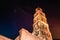 Saint Dominus belltower seen from below, long exposure, illuminated by orange lights at night, beautiful colorful night sky with