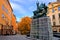 Saint George and the Dragon statue and colorful street during autumn in the Old Town of Gamla Stan, Stockholm, Sweden