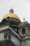 Saint Isaac`s Cathedral golden cupola dome, statues, granite columns close up on grey cloudy sky background