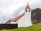 Saint Joseph`s Catholic church, Edinburgh of the Seven Seas town, Tristan da Cunha. A whale and cardinal direction pointer signs
