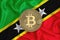 Saint kitts flag, bitcoin gold coin on flag background. The concept of blockchain, bitcoin, currency decentralization in the