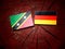 Saint Kitts and Nevis flag with German flag on a tree stump isolated