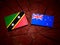 Saint Kitts and Nevis flag with New Zealand flag on a tree stump