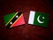 Saint Kitts and Nevis flag with Pakistan flag on a tree stump is