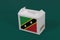 Saint Kitts and Nevis flag on white box with barcode and the color of nation flag on green background. The concept of export