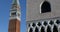 Saint Mark bell tower and Doge palace tilt view in a sunny day in Italy, blue sky