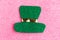 Saint Patrick leprechaun paper hat isolated on pink glitter background.