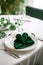 Saint Patrick's Day dining concept, green napkin with clover, elegant plate, sophisticated setting, copy space