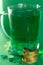 Saint Patricks day backdrop with bear cup with ale, stack of chocolate coins, green four-leafed paper clovers