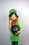 Saint Patricks Day. Cute laughting small girl with decorative red beard in green dress and leprechaun\\\'s hat