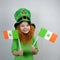 Saint Patricks Day. Endearing smiling little girl with decorative red beard, dressed in green, in leprechaun\\\'s hat