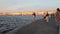 Saint Petersburg, the Arrow of Vasilievsky island, people walk along the embankment of the Neva river, sunset.