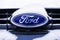 Saint-Petersburg, Russia - Janury 28, 2019 - A closeup of a blue chrome ford logo on a front grid Ð° the car covered with white