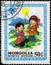 Saint Petersburg, Russia - May 17, 2020: Postage stamp issued in Mongolia with the image of Children in traditional clothes