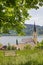 Saint Sixtus church Schliersee, lonely bench and chestnut branches, spring landscape bavaria