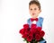 Saint Valentine`s day. Handsome gentleman boy with blue vest, red tie, red roses bucket and red balloons . Valentines day kids. L