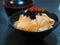 Sake Salmon Rice Japanese Style Chirashi scattered topping with Tobiko Flying fish roe in black bowl