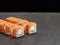 Sake salmon sushi roll with cucumber and cream cheese inside roll on dark concrete background