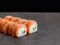 Sake salmon sushi roll with cucumber and cream cheese inside roll on dark concrete background