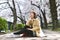 Sakura cherry blossoms full blooming, Asian smiling woman traveler sitting under the pink flower tree.