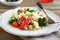 Salad with arabic couscous and vegetables on a white plate