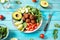 Salad with avocado, falafel, cucumber, cherry tomato and spinach on blue wood background