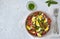 Salad from baked eggplants, onions, tomatoes, eggs, dressed with olive oil and apple vinegar on a light background. Copy space