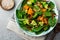 Salad with a baked pumpkin, chard, broccoli, and pumpkin seeds in ceramic plate on stone or concrete background table background.