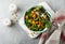 Salad with a baked pumpkin, chard, broccoli, and pumpkin seeds in ceramic plate on stone or concrete background table background.