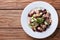 Salad with beans, meat and fresh cucumber on a wooden