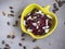 Salad of boiled beets and seeds, feta cheese in a yellow ceramic salad bowl, seasoned with vegetable oil. On a wooden gray